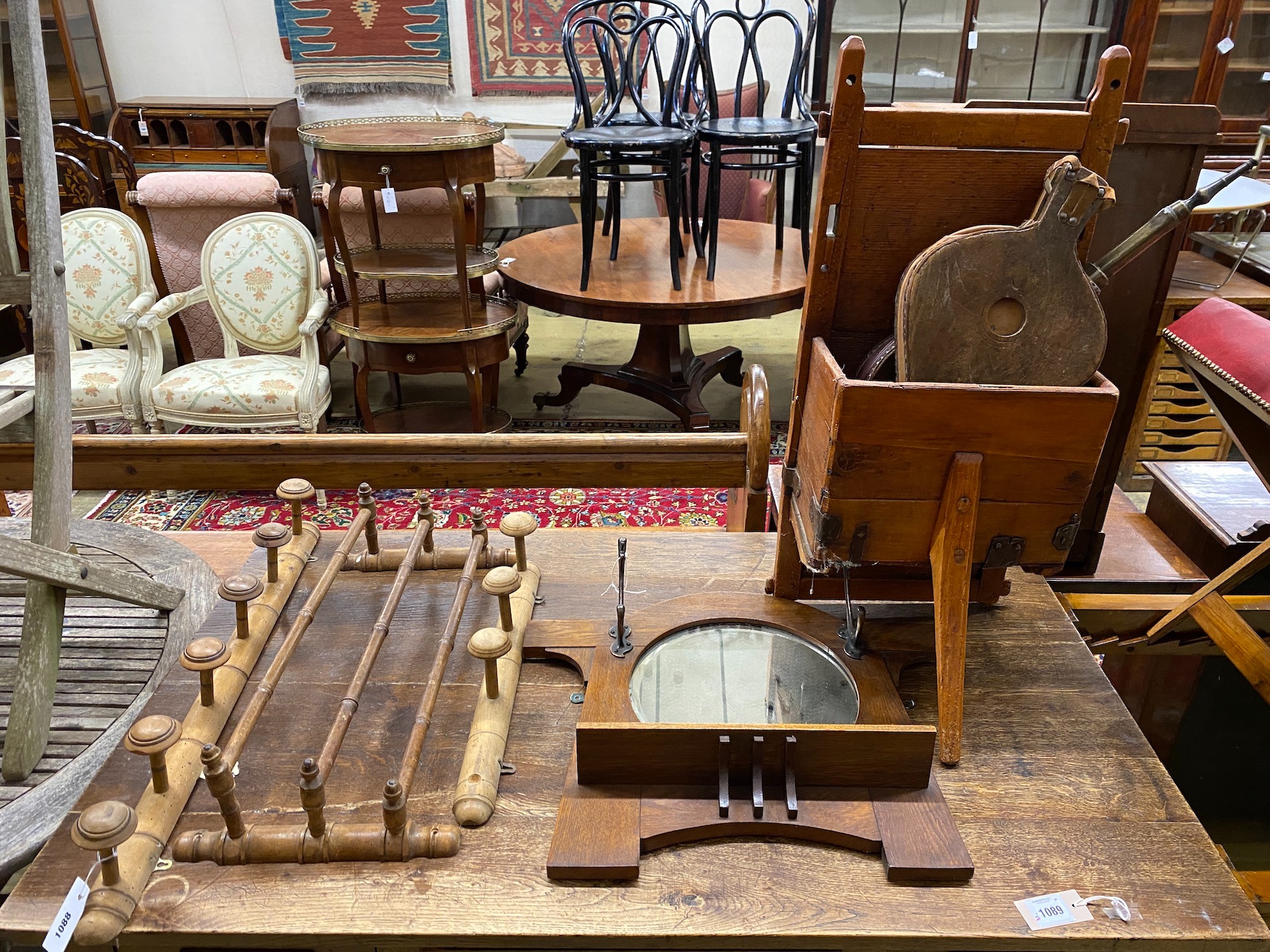 A hall mirror, two late Victorian beech coat racks, a hanging rail, two pairs of bellows, and a cheese carrier